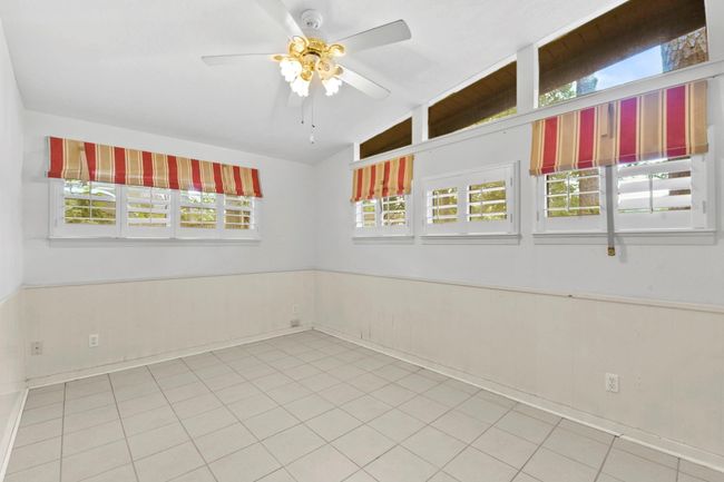 This inviting bedroom features elegant plantation shutters, adding charm and privacy. | Image 16