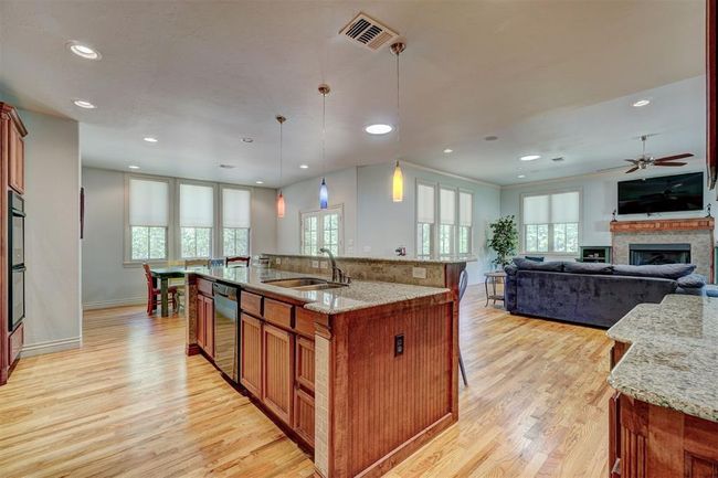 Kitchen featuring light wood-style floors, visible vents, a sink, and brown cabinets | Image 15