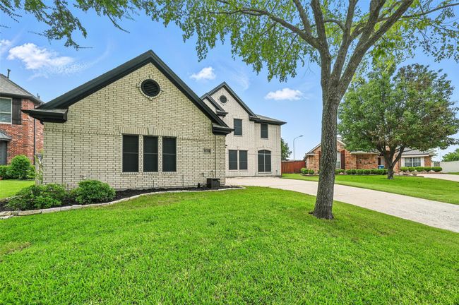 View of front facade with brick siding, a front yard, and concrete driveway | Image 4