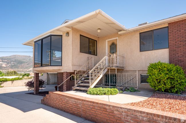View of front of property with stucco siding, a mountain view, and stairs | Image 53