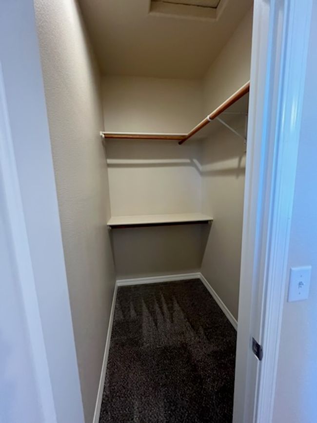 Walk in closet featuring attic access and carpet | Image 21