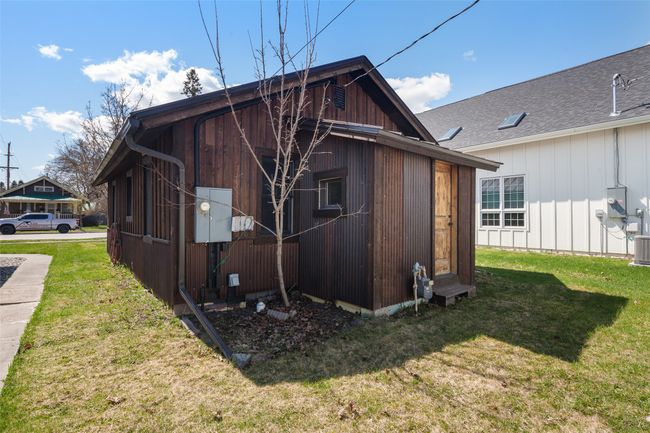 Rear view of house with a yard and roof with shingles | Image 24