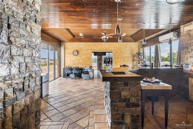 View of patio with an AC wall unit, a ceiling fan, and area for grilling | Image 13