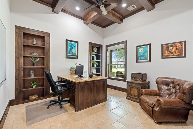 The beautiful Travertine flooring continues into the Study and is anchored by the tastefully, formal, stained baseboards and coffered ceiling. A front-facing window directly overlooks the Front Porch and expansive Front Yard just beyond. The pair of built-in wood bookcases provide ample space to showcase your favorite books, pictures, and family mementos. | Image 7