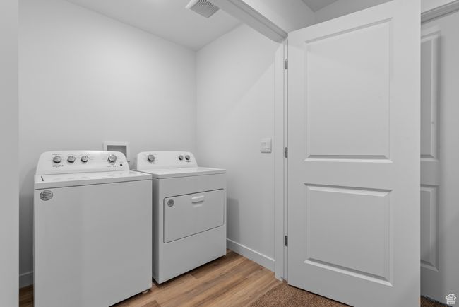 Washroom with washer and clothes dryer and light wood-style flooring | Image 13