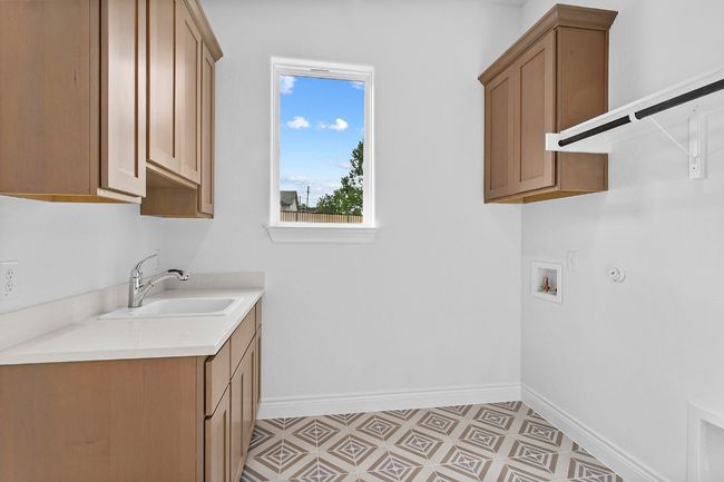 Laundry area with cabinet space, hookup for a washing machine, and light floors | Image 27