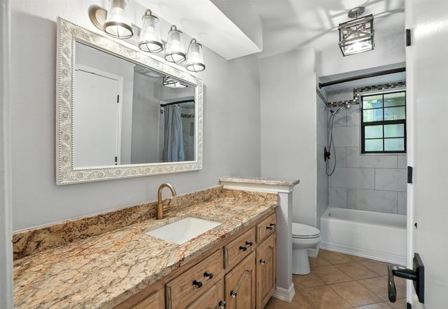 Full bath with vanity, tile patterned flooring, and shower / tub combo | Image 15