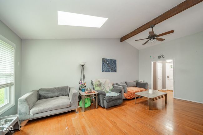 living room featuring wood finished floors, a skylight, and a ceiling fan | Image 11
