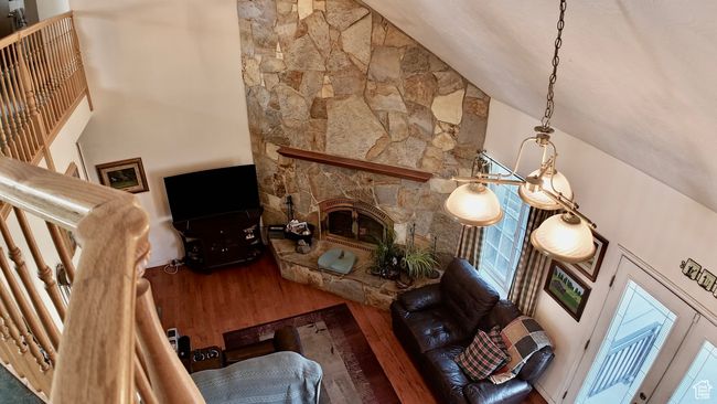 Living room with high vaulted ceiling, a fireplace, and wood finished floors | Image 72