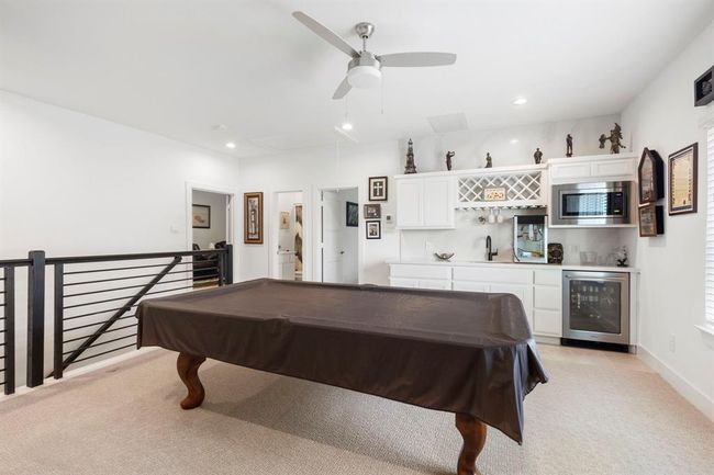 Spacious upstairs game room with a pool table, wet bar, and modern amenities—perfect for entertaining. | Image 36