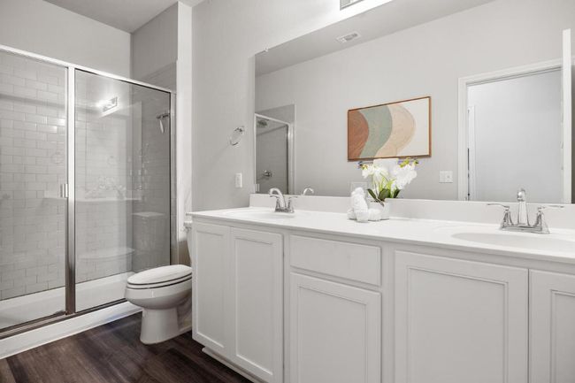 Full bath with toilet, a shower stall, double vanity, and wood finished floors | Image 10