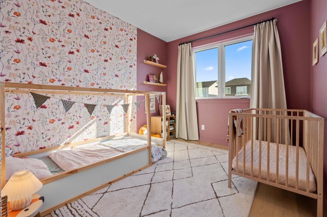 Bedroom with wallpapered walls, a crib, and wood finished floors | Image 23