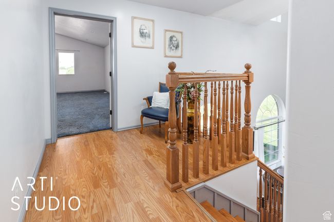 Corridor featuring an upstairs landing, lofted ceiling, wood finished floors, and baseboards | Image 25
