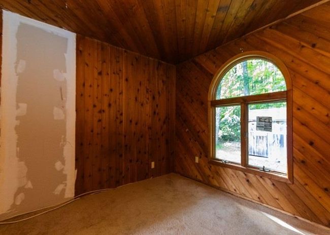 Carpeted spare room with wooden walls, lofted ceiling, and wooden ceiling | Image 9