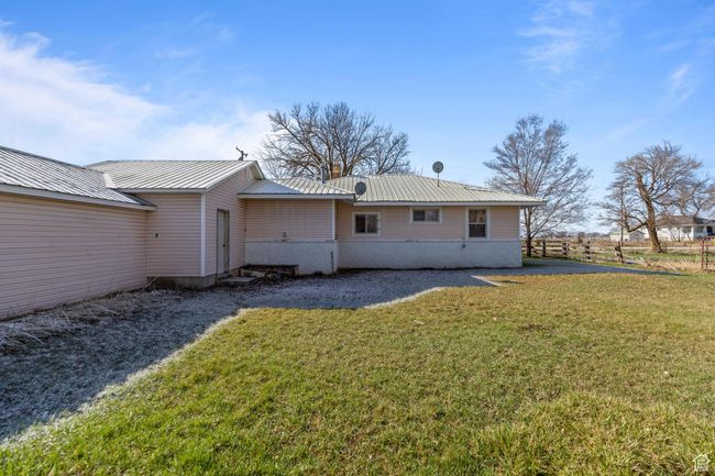 Rear view of property with a lawn and metal roof | Image 4