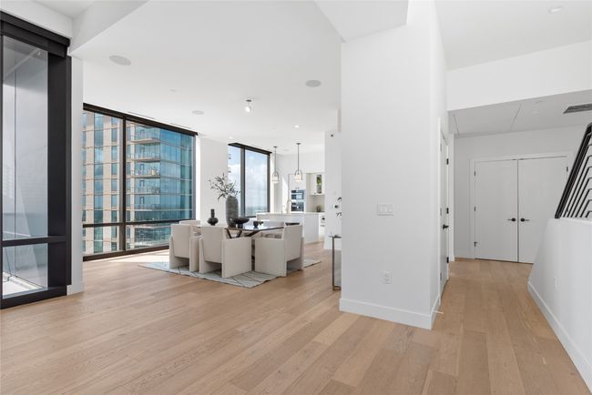 Living area with light wood-type flooring and a wall of windows | Image 30