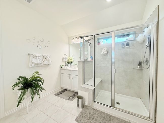 Bathroom with vanity, tile patterned floors, a shower stall, and lofted ceiling | Image 30