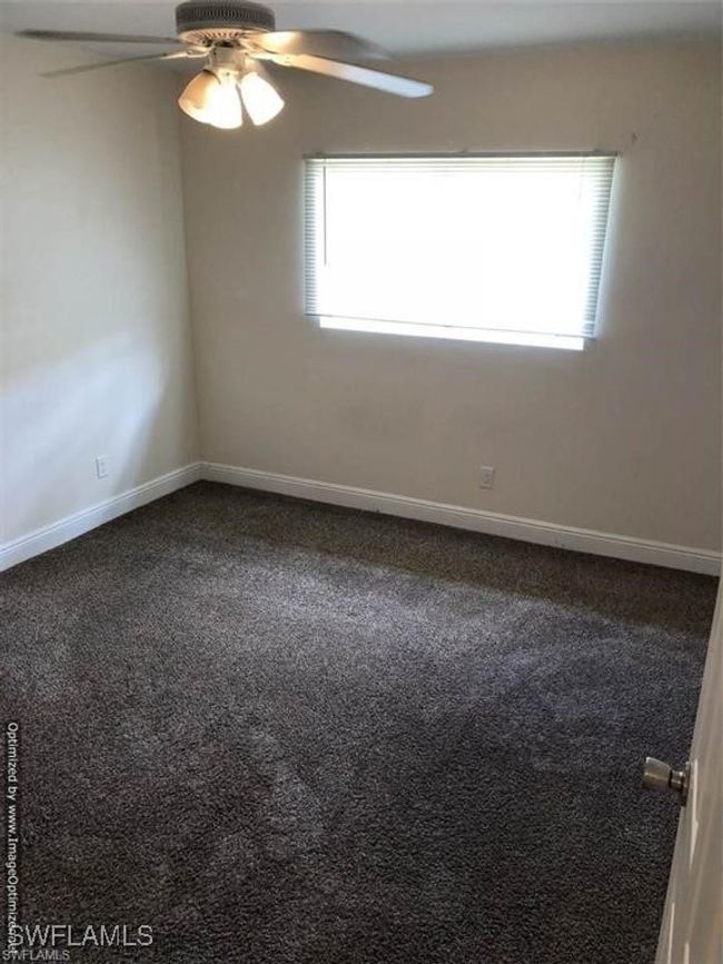 Spare room featuring a wealth of natural light, ceiling fan, and carpet | Image 9