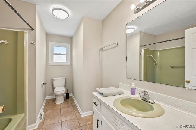 Full bath featuring baseboards, toilet, tile patterned flooring, and vanity | Image 24