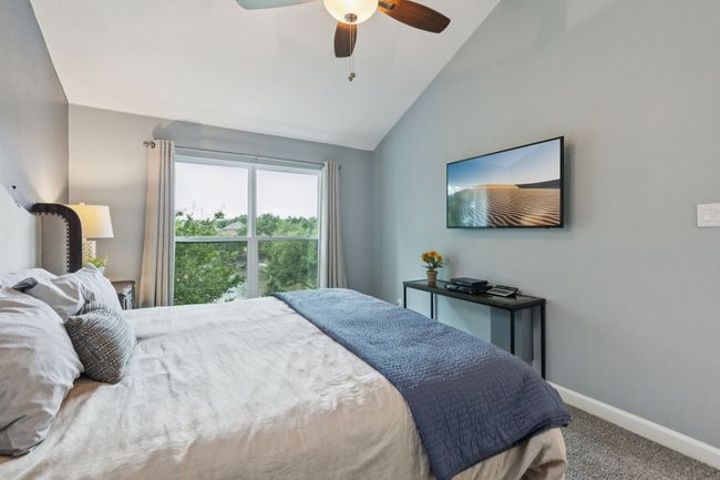 Bedroom featuring carpet, baseboards, lofted ceiling, and ceiling fan | Image 18