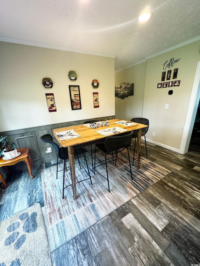 Dining room featuring crown molding, a textured ceiling, and wood finished floors | Image 17