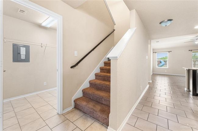 Staircase featuring electric panel, tile patterned floors, and a ceiling fan | Image 19