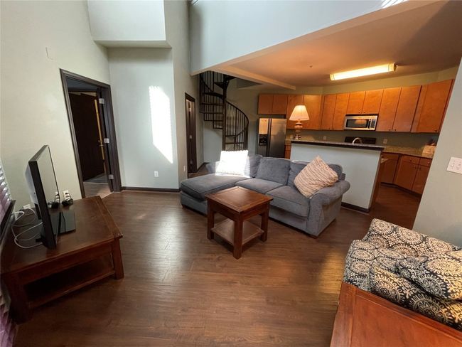Living room with stairs, dark wood-style floors, and a high ceiling | Image 7
