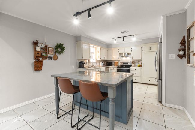 Kitchen with a peninsula, appliances with stainless steel finishes, track lighting, and a sink | Image 9