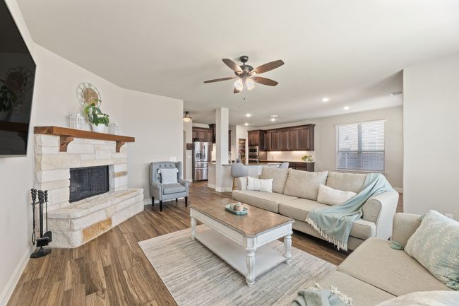 Living room with ceiling fan, wood finished floors, recessed lighting, and a stone fireplace | Image 4