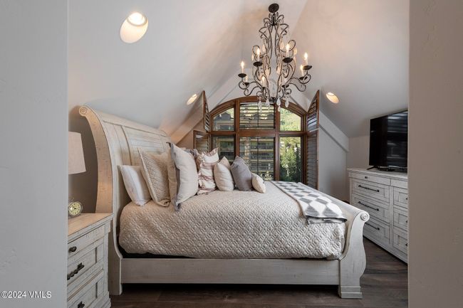 Tucked under the eaves with custom millwork and a dramatic chandelier, this guest suite feels like a luxurious hideaway in the heart of the Alps. Architectural charm meets peaceful privacy. | Image 12