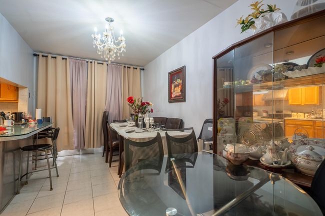 Dining area featuring a chandelier and light tile patterned flooring | Image 7