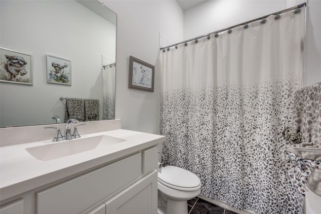 Full bathroom featuring toilet, curtained shower, and vanity | Image 18