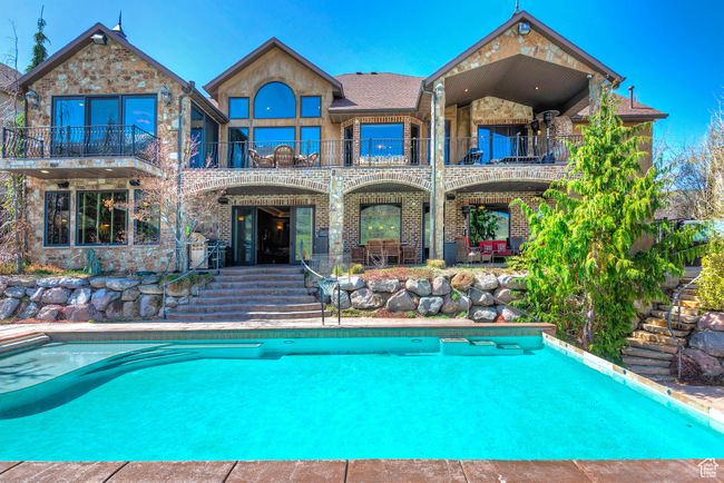 Rear view of property with a patio, an outdoor pool, and a balcony | Image 64