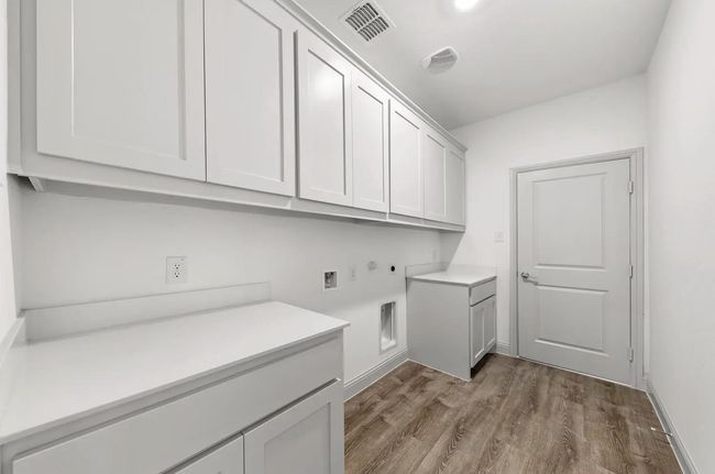 Laundry room featuring cabinet space, hookup for a washing machine, and dark wood-style flooring | Image 10