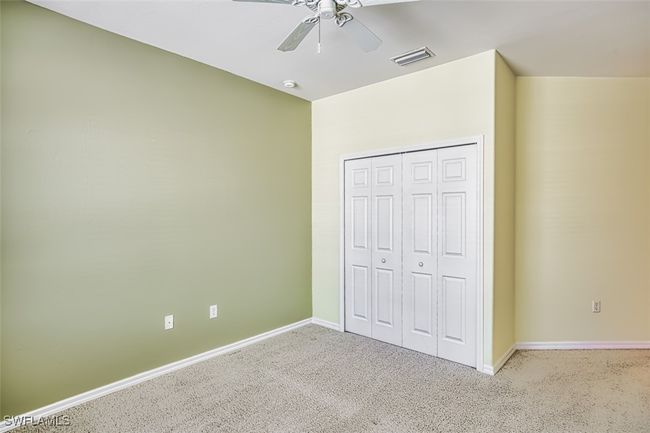 Unfurnished bedroom with carpet flooring, ceiling fan, and a closet | Image 40