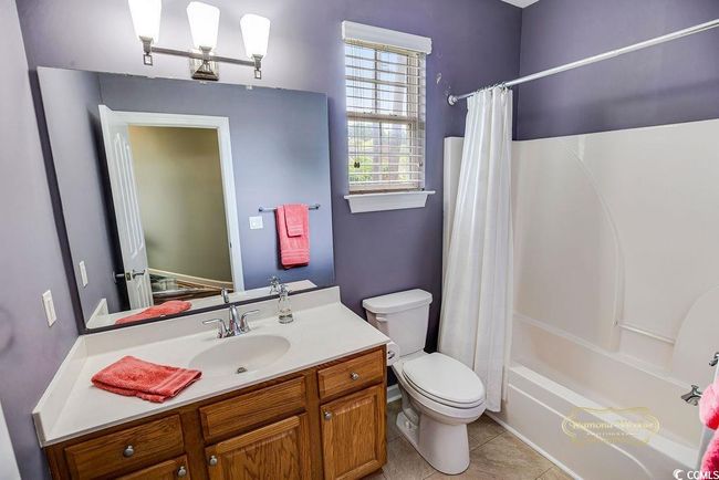 Full bathroom with vanity, shower / tub combo, and tile patterned flooring | Image 25