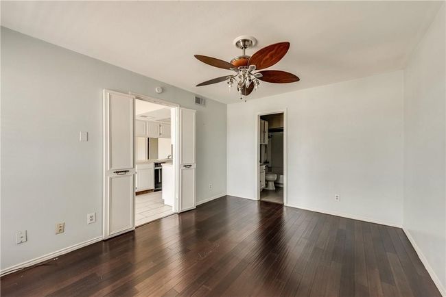 Unfurnished room featuring ceiling fan and dark wood finished floors | Image 9
