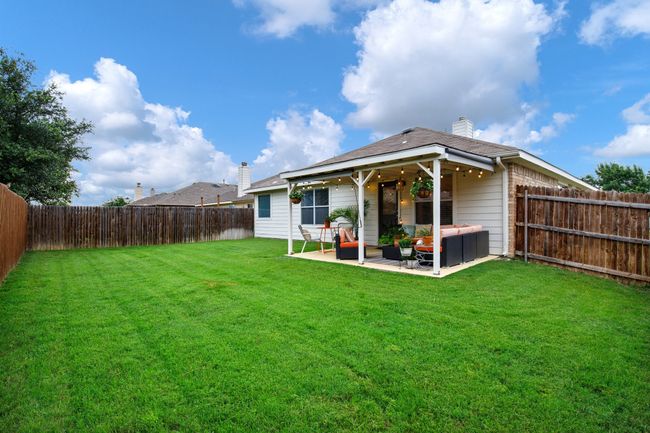 Rear view of property featuring an outdoor hangout area, a fenced backyard, a chimney, and a patio | Image 25