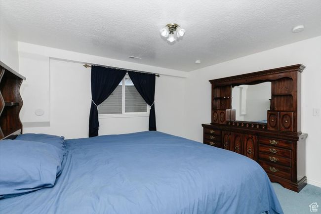 Carpeted bedroom featuring a textured ceiling | Image 58