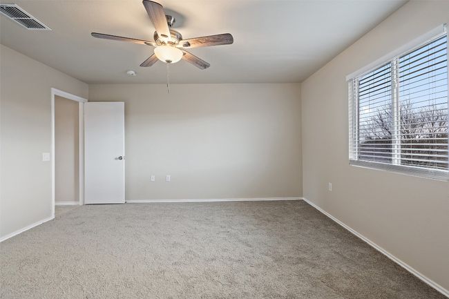 Carpeted empty room featuring a ceiling fan and baseboards | Image 18