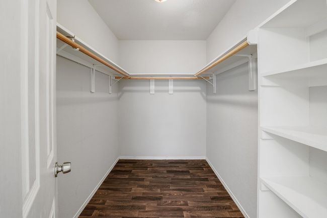 Walk in closet with dark wood-style floors | Image 19