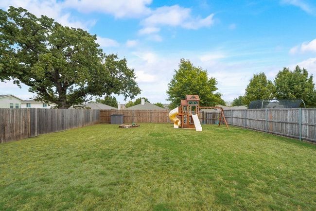 Fenced backyard featuring a playground | Image 24