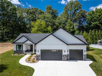 Modern inspired farmhouse with a front lawn and a garage | Image 1