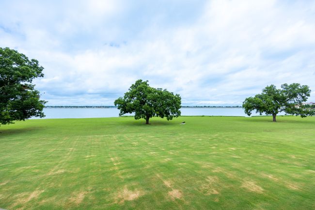 View of green lawn featuring a water view and view of golf course | Image 24