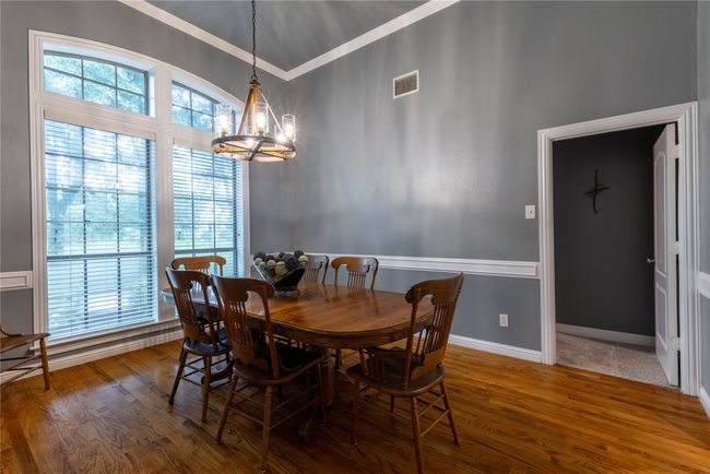 Dining room with a chandelier, crown molding, and wood finished floors | Image 16