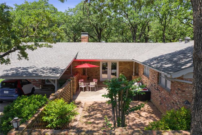 Back of property with a chimney, brick siding, a shingled roof, french doors, and a patio | Image 16