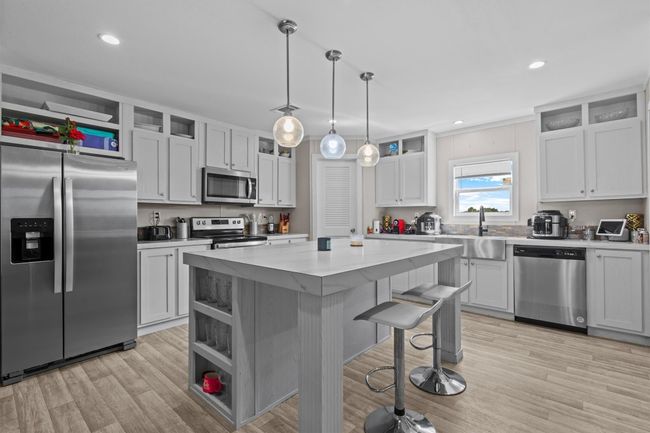 The centerpiece is a spacious 2, 061 sq ft manufactured home, just 1.5 years old, with 4 bedrooms, 2 bathrooms, and a beautifully crafted 40' x 20' stone outdoor kitchen under a covered roof with lighting—ideal for hosting under the stars. | Image 4