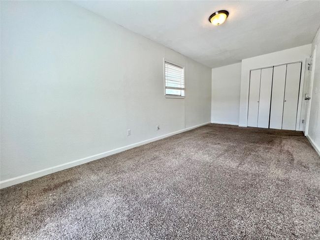 Unfurnished bedroom with baseboards, carpet floors, and a closet | Image 13