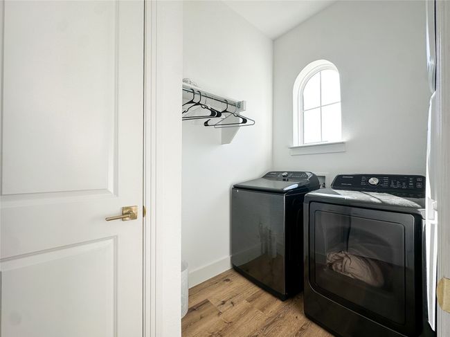 Laundry room with washing machine and clothes dryer and light wood-style flooring | Image 27