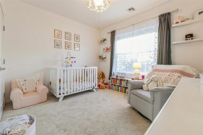 Bedroom with a crib, visible vents, and carpet floors | Image 9